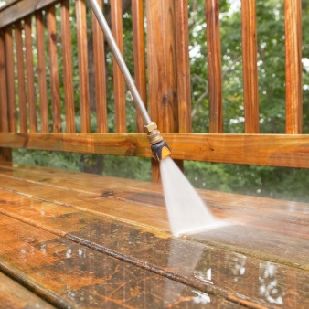 Pressure Washer Cleaning a Weathered Deck